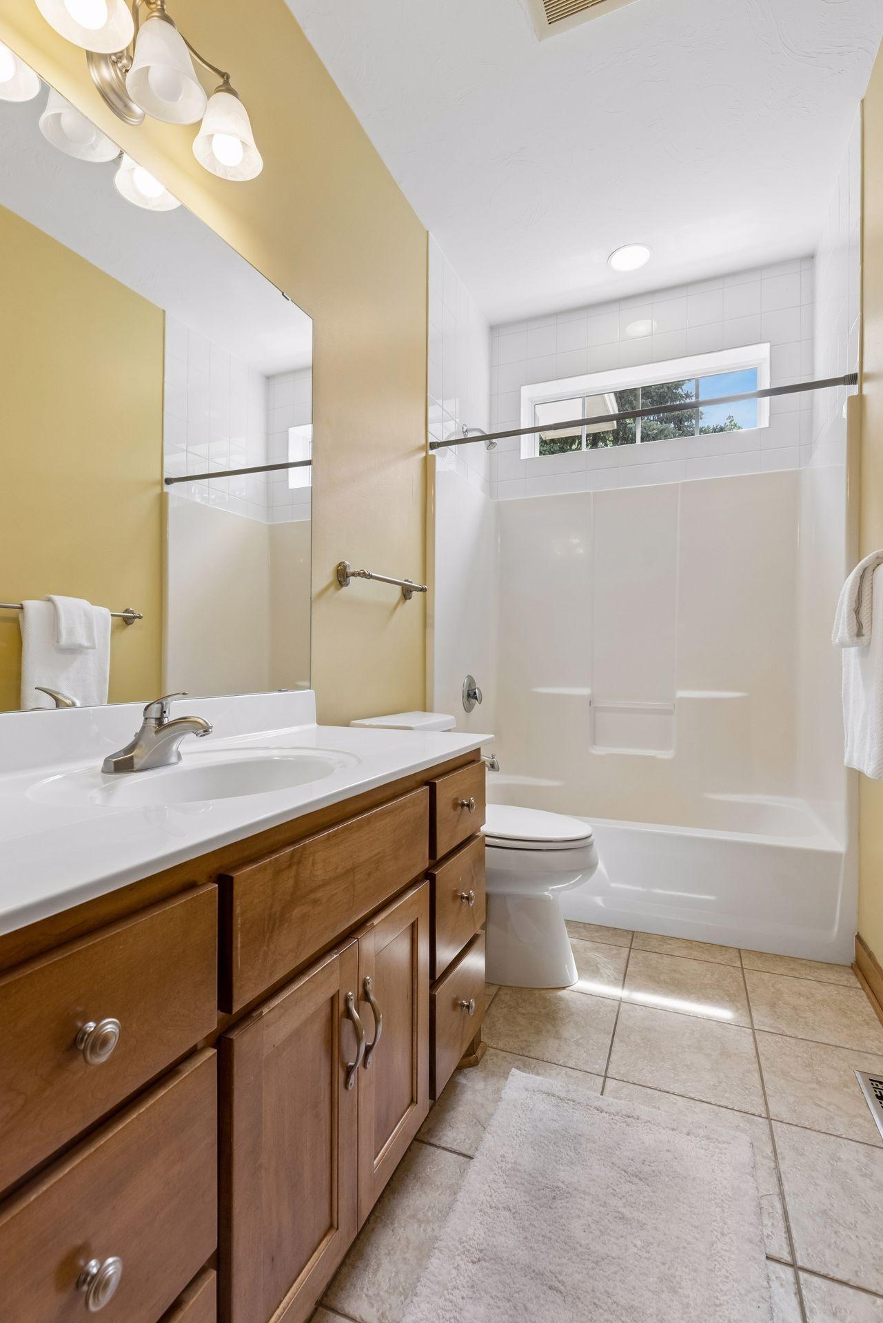 Main floor full bathroom with tile floors, tall ceilings.