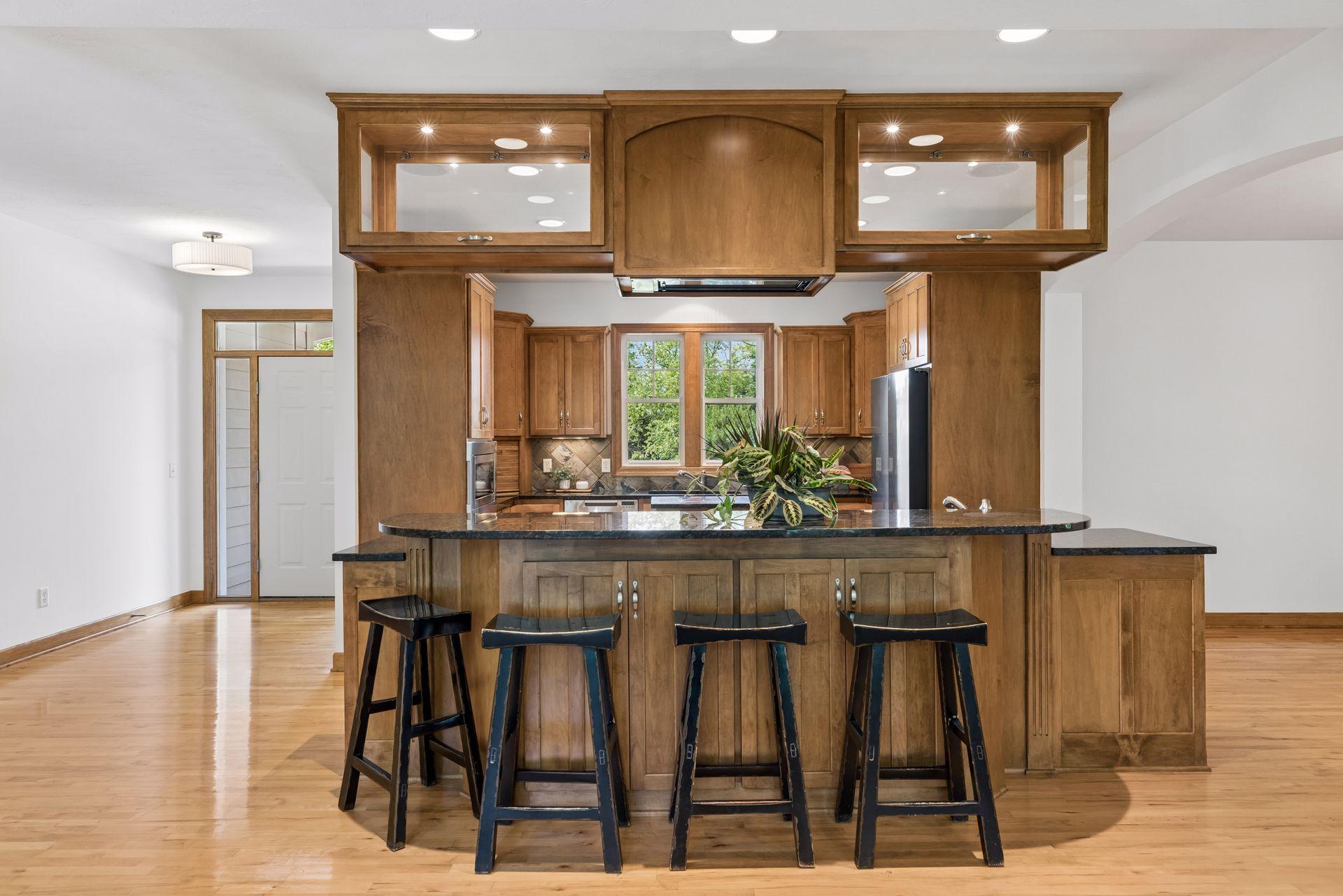 Rich maple cabinetry, hardwood floors, granite countertops, and extensive custom woodwork. Cabinets on both sides of the island.