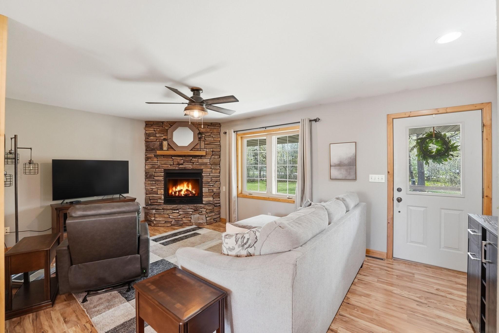 Cozy living room off kitchen with beauiful stone gas fireplace