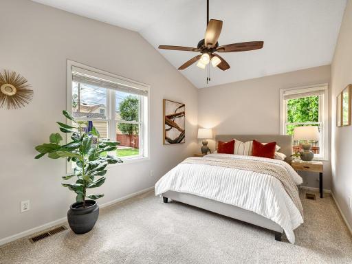 Spacious primary bedroom has vaulted ceiling and outdoor views!