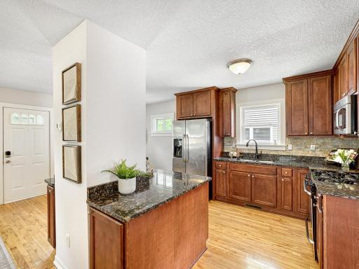 Stylish kitchen offers solid surface countertops, tiled backsplash ...