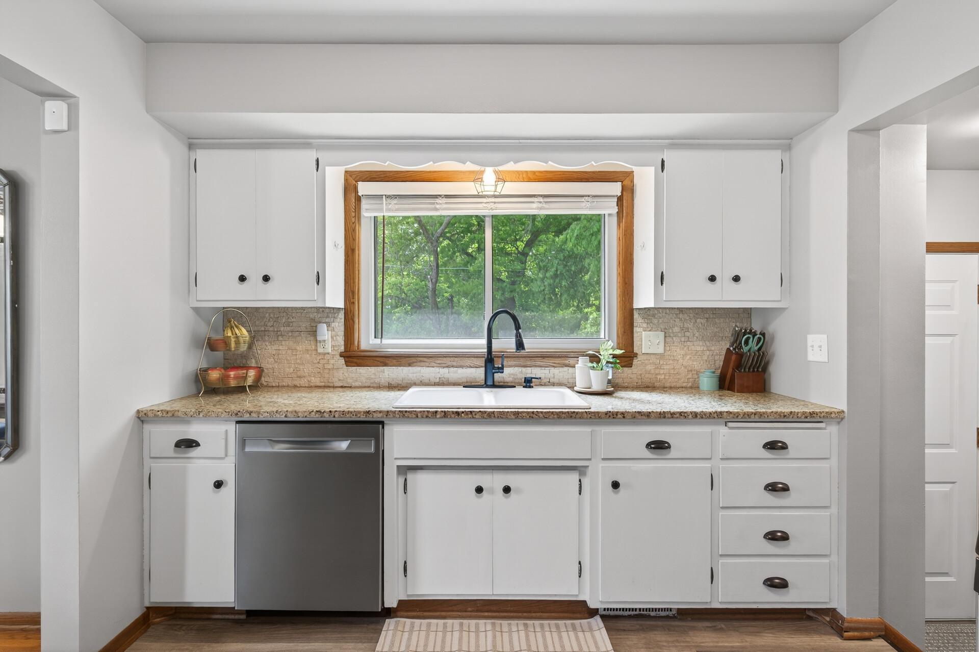 The oversized window above the kitchen sink fills the space with natural light and provides an idyllic view of the private backyard.