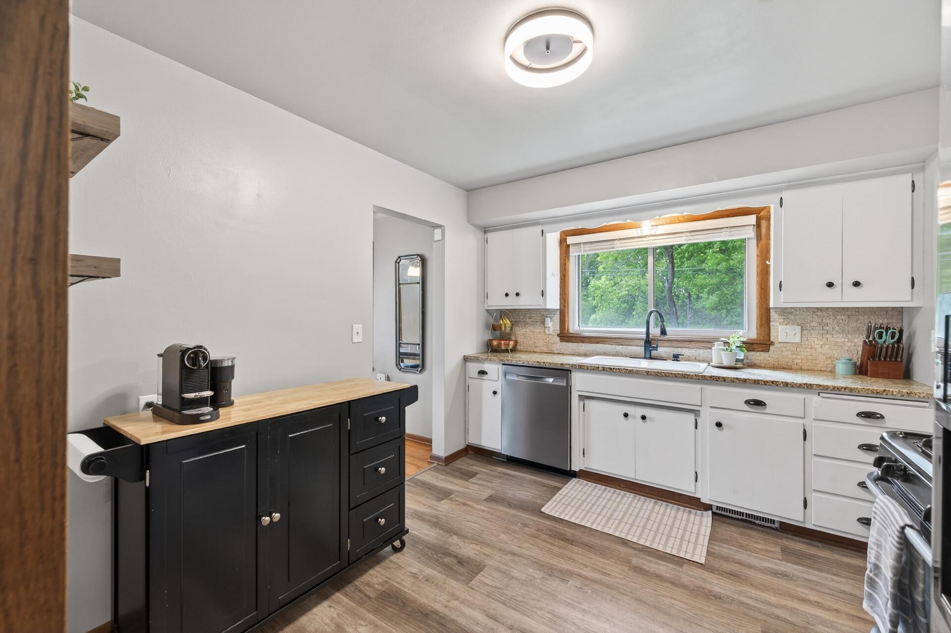 The kitchen offers space for a rolling island for additional storage (to be included in the sale if desired).