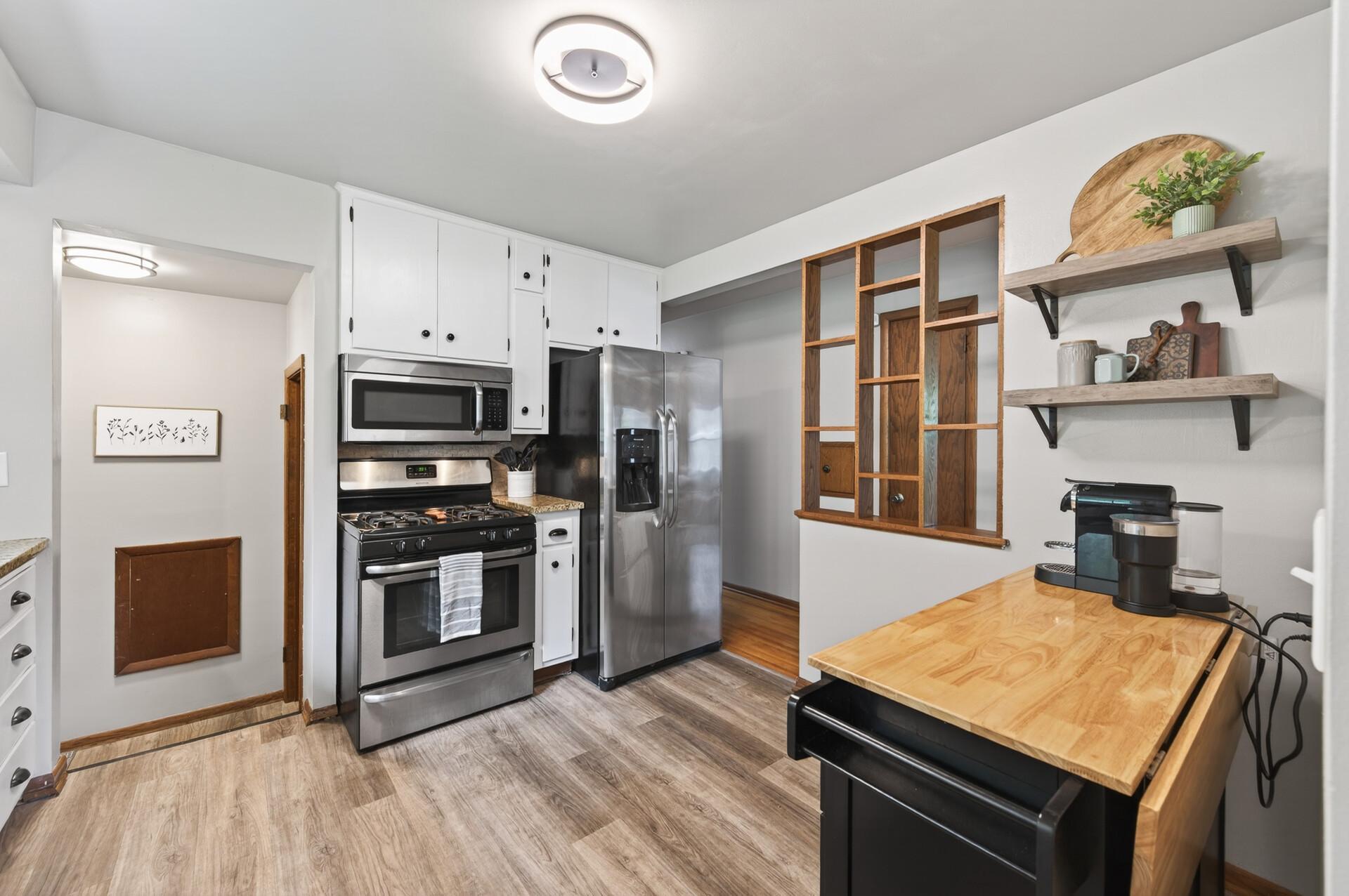 The spacious kitchen features granite countertops, stainless steel appliances, and luxury vinyl flooring.