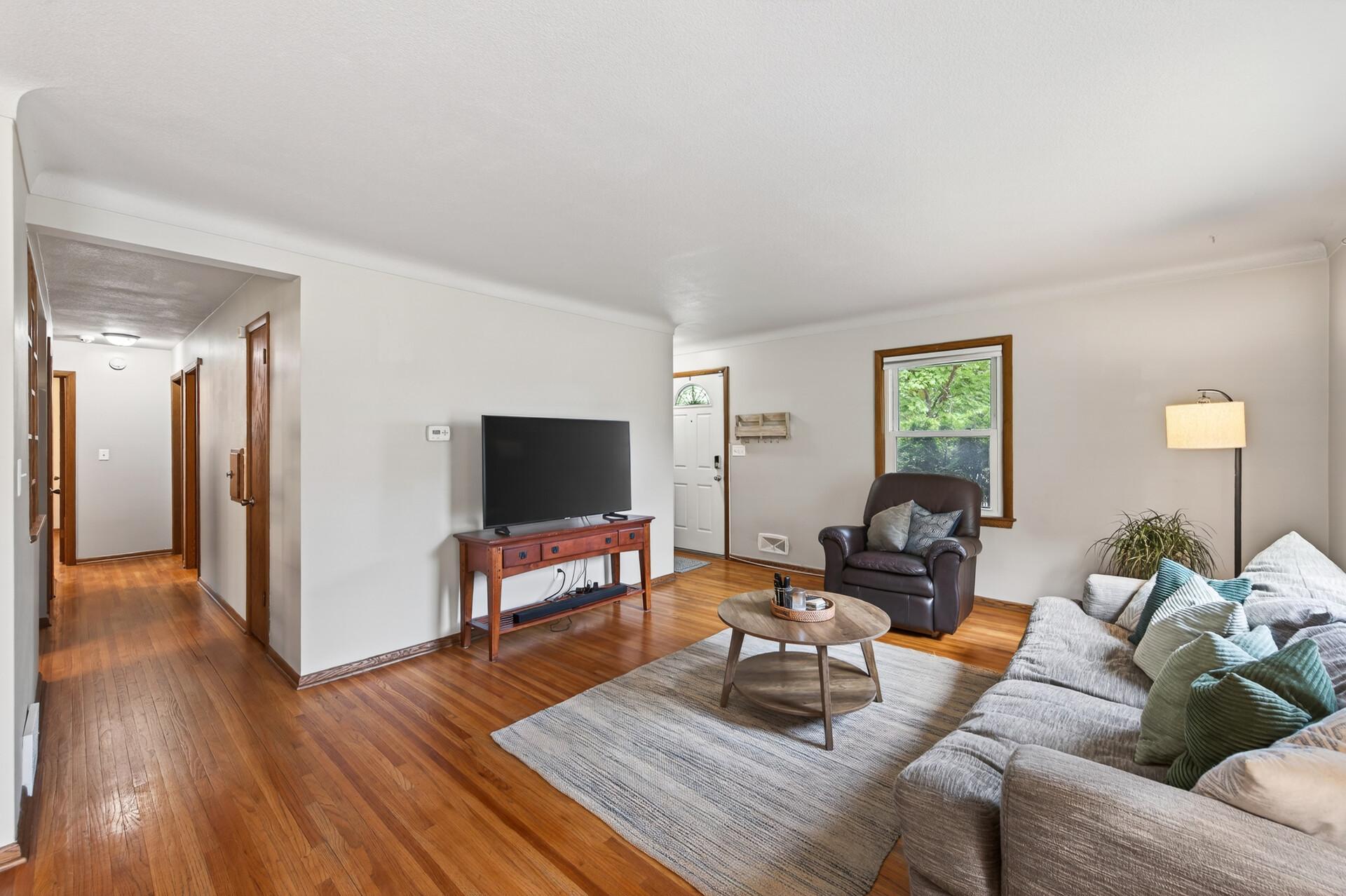 The bright, cozy living room welcomes you when you first enter the home, with original hardwood floors that flow throughout the main level.