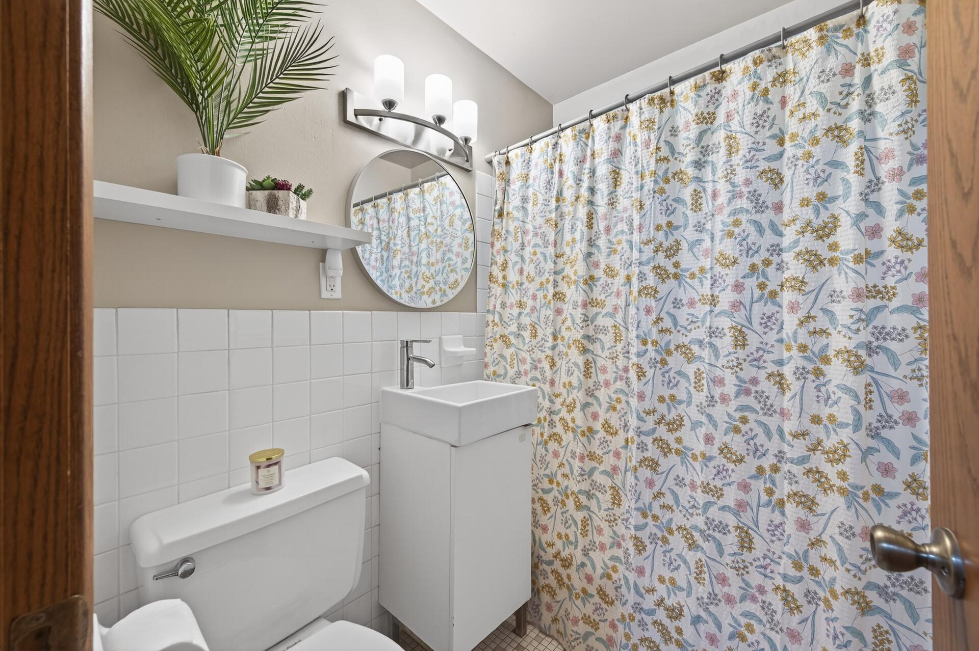 The bright, meticulously maintained full bathroom on the main floor features tiled walls and floors.