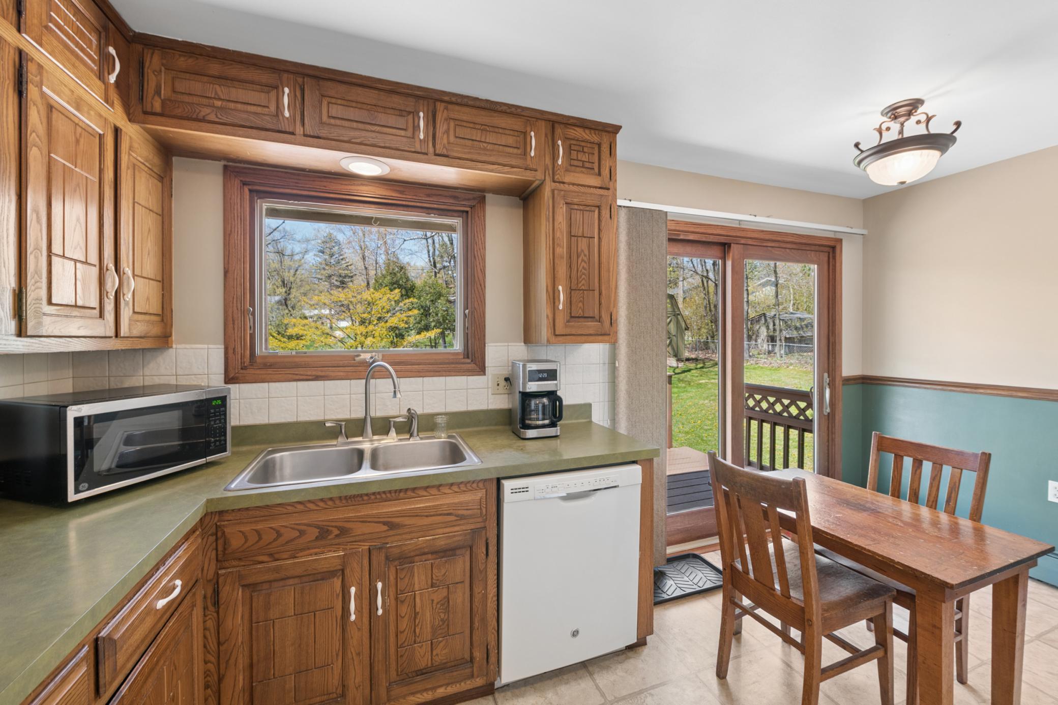 Eat-in kitchen features sliding patio door to large 2-tier deck