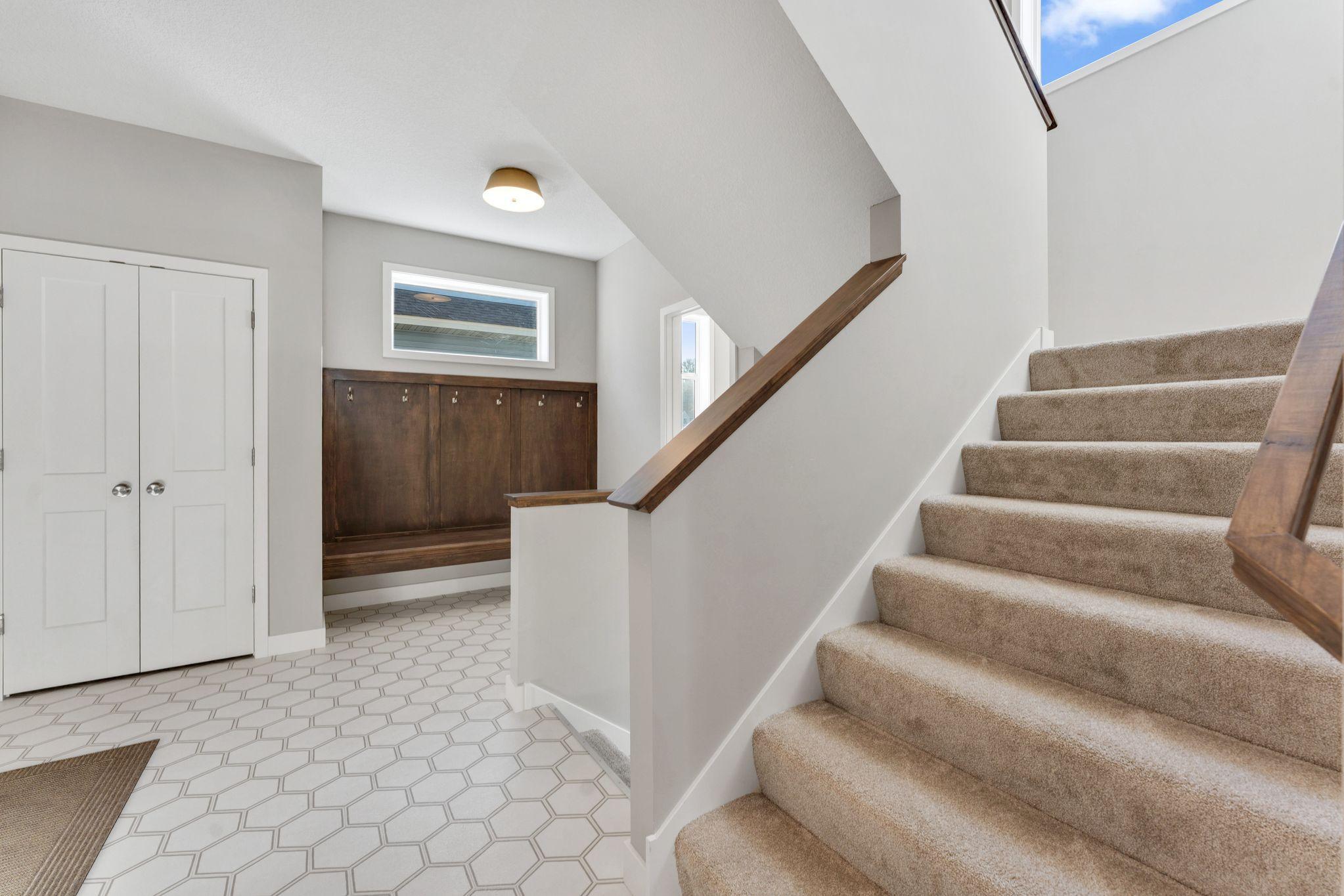 Spacious mudroom with plenty of storage and a bench with hooks to hang additional items