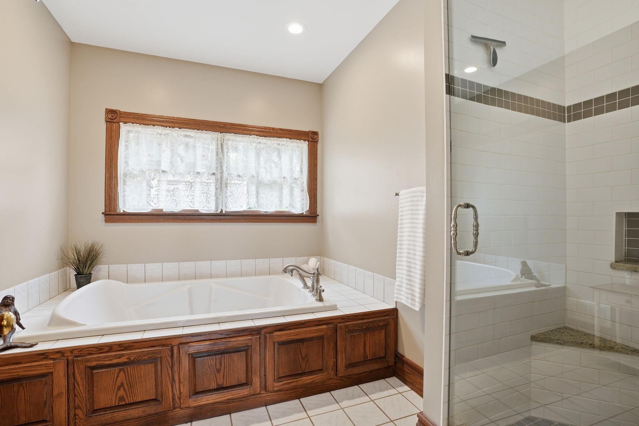 Primary bath includes massive jetted tub and tiled shower.