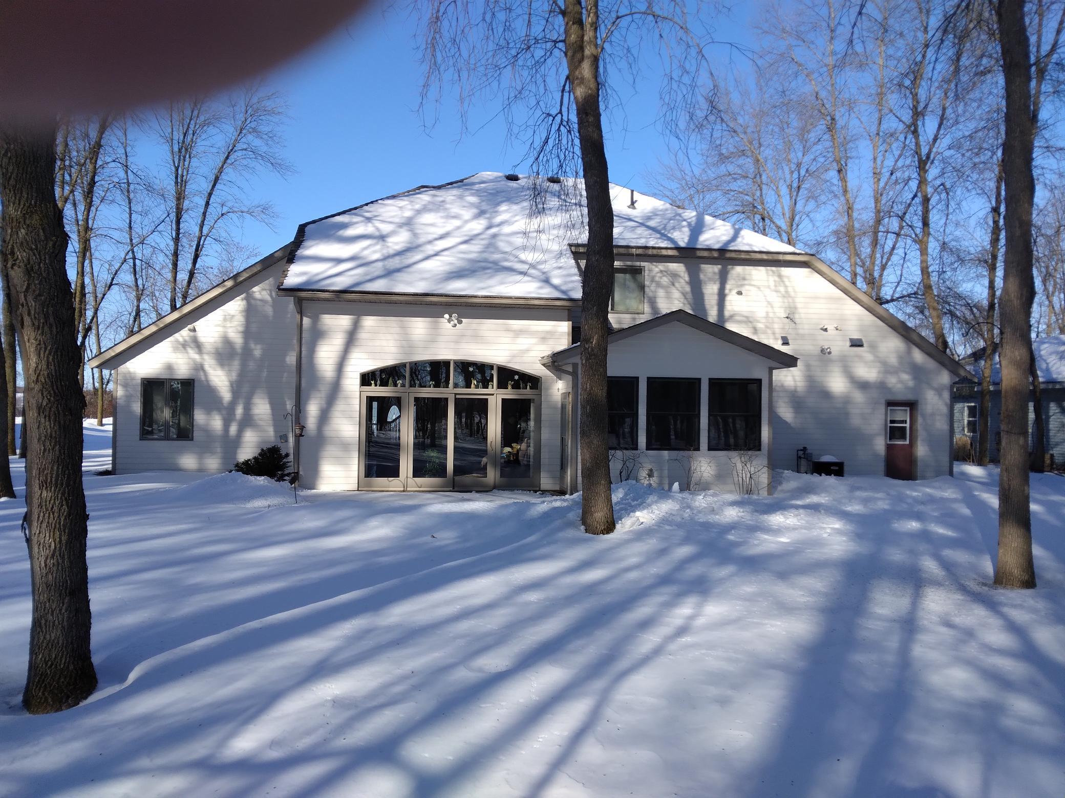 Back of home showing patio door in living room, 4 season porch,