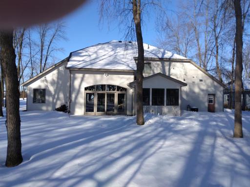 Back of home showing patio door in living room, 4 season porch,