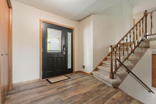 Inviting entryway with updated luxury vinyl flooring and front closet and updated, new front door
