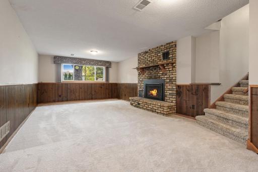 Cozy, spacious lower level family room space with fireplace converted now to a gas fireplace