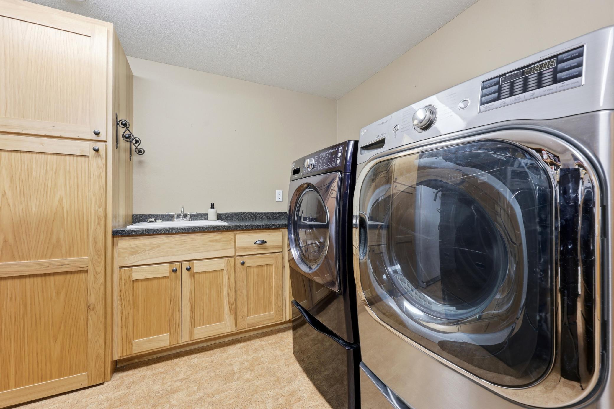 Laundry (lower level) with laundry sink & cabinets (washer & dryer included)