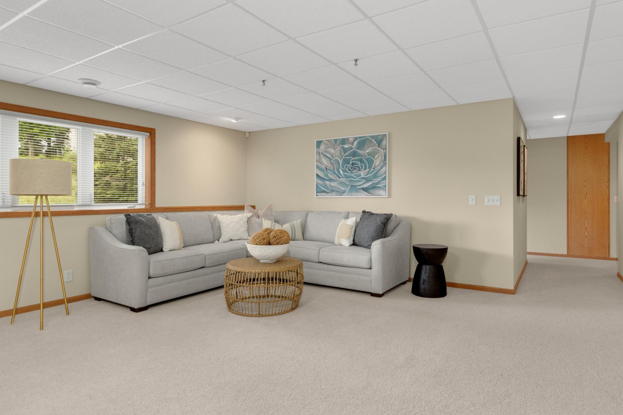 The spacious lower-level family room is perfect for movie nights, game days, or relaxing