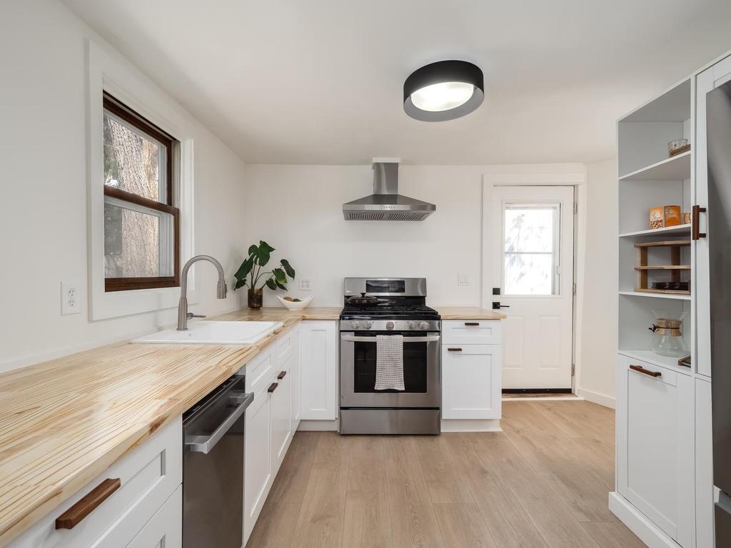 Kitchen with dishwasher, gas range, and hood vent