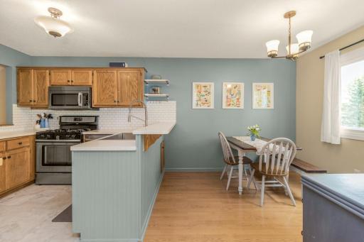 Step into the adjacent kitchen with soft colors, stainless steel appliances (gotta love the farm style sink too!), and plenty of counter space. Informal dining space could easily accommodate a bigger table without the coffee bar