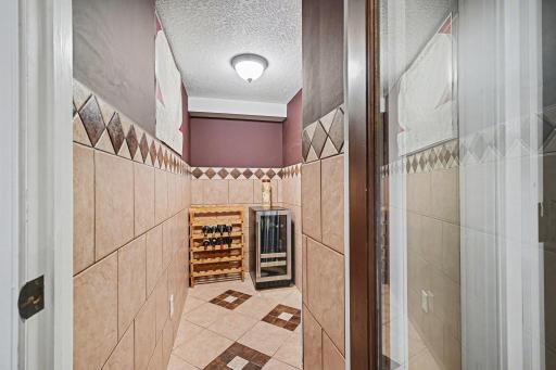 Design meets function! This dedicated wine closet is finished with ceramic tile and a modern glass door. Ideally located in the lower-level entertainment area, itâs a high-end touch that truly sets this home apart.