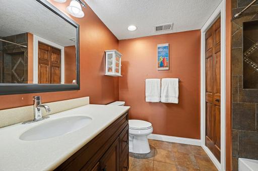 A second full bath with premium finishes! Features a large comfort-height vanity, ceramic tile floors, and a brand-new comfort-height toilet (2025). The tile tub surround includes a built-in shampoo niche and a convenient linen closet.