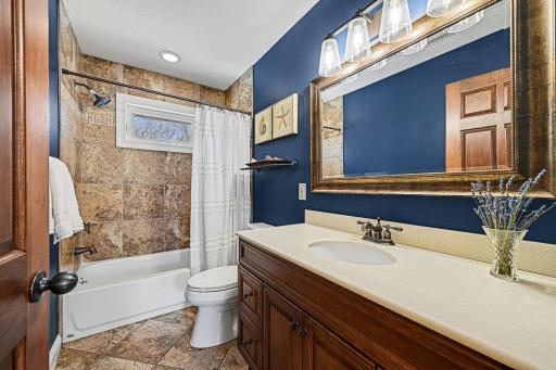 The lovely main-level full bath is perfectly updated! Features a large comfort-height vanity with storage, ceramic tile floors, and a tile tub surround. A newer comfort-height toilet and a bright window make this space feel fresh and modern.