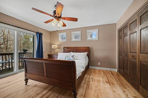 Elegance meets nature! Enjoy gorgeous hardwood floors and a private patio door that opens to your own bedroom deck overlooking your wooded backyard. Features a large closet, ceiling fan, and modern knockdown ceilings. A peaceful main-level sanctuary.