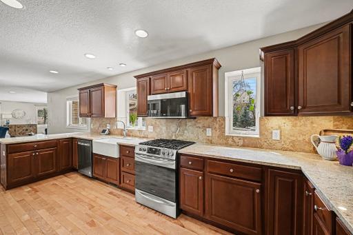Modern updates at every turn! Granite tops, ceramic backsplash, and stainless steel appliances shine under 3 bright windows. Enjoy rich hardwoods and loads of cabinet space in this perfectly functional, sun-drenched kitchen layout.