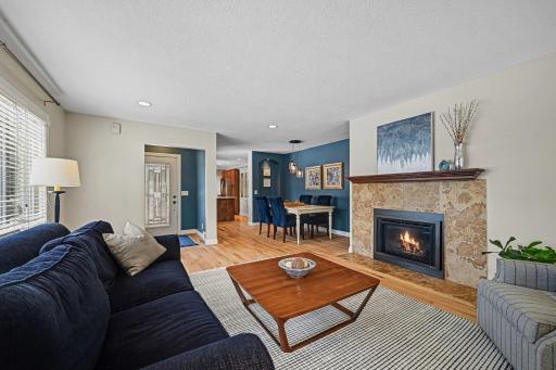 Another view of the beautiful living room and dining room. Cozy up by the fireplace with a good book or good company.