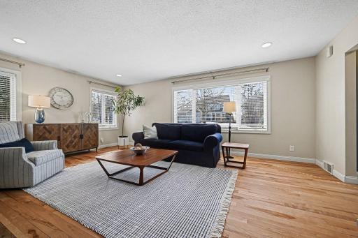 Natural light from the large picture window highlights the rich texture of the white birch hardwood floors. Note the seamless knockdown ceilings and integrated recessed lighting. Every detail reflects the many updates throughout this Minnetonka gem.