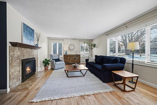 Modern elegance at its finest. Stunning living room with white birch hardwoods & a cozy Fireside Hearth & Home gas fireplace. Natural light pours through the large picture window, highlighting the knockdown ceilings & recessed lighting.