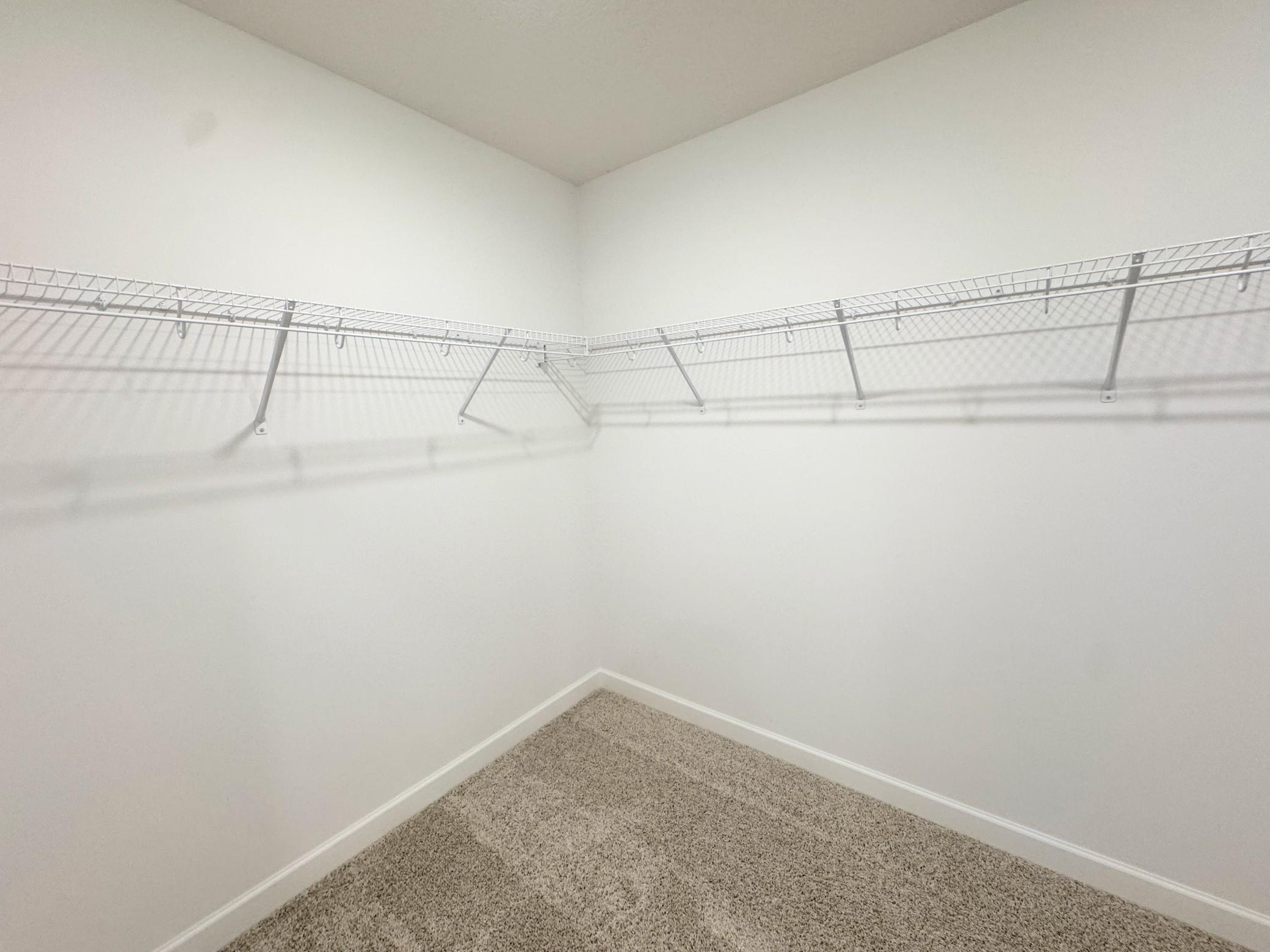 The walk-in closet has mesh wire shelving for ample wardrobe storage