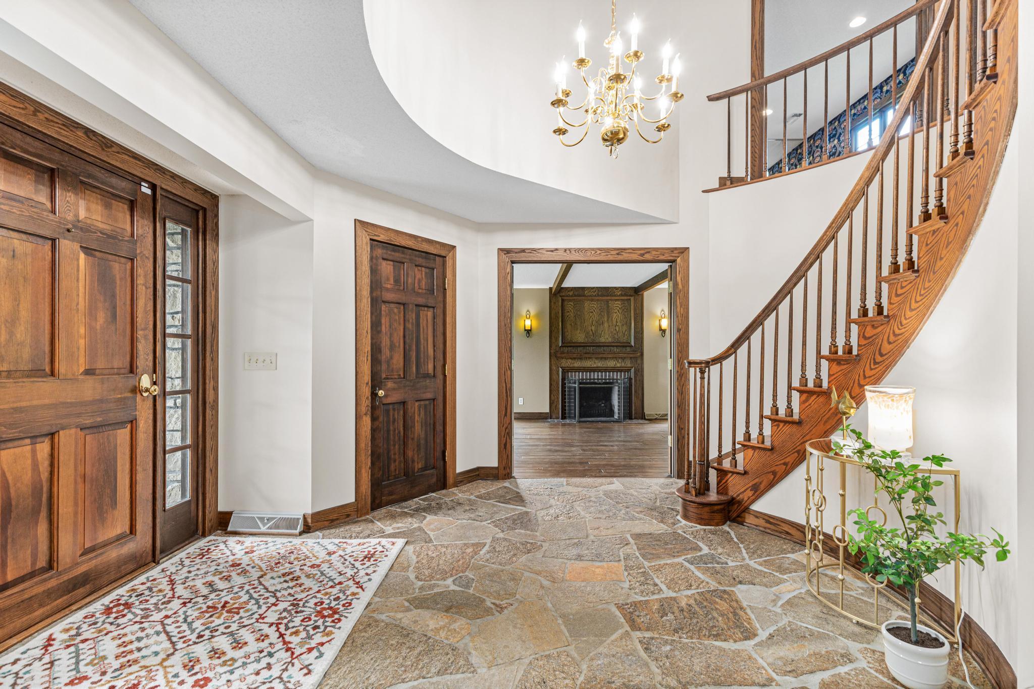 Dramatic two-story foyer welcomes you with elegance and natural light. Formal living room in the distance.