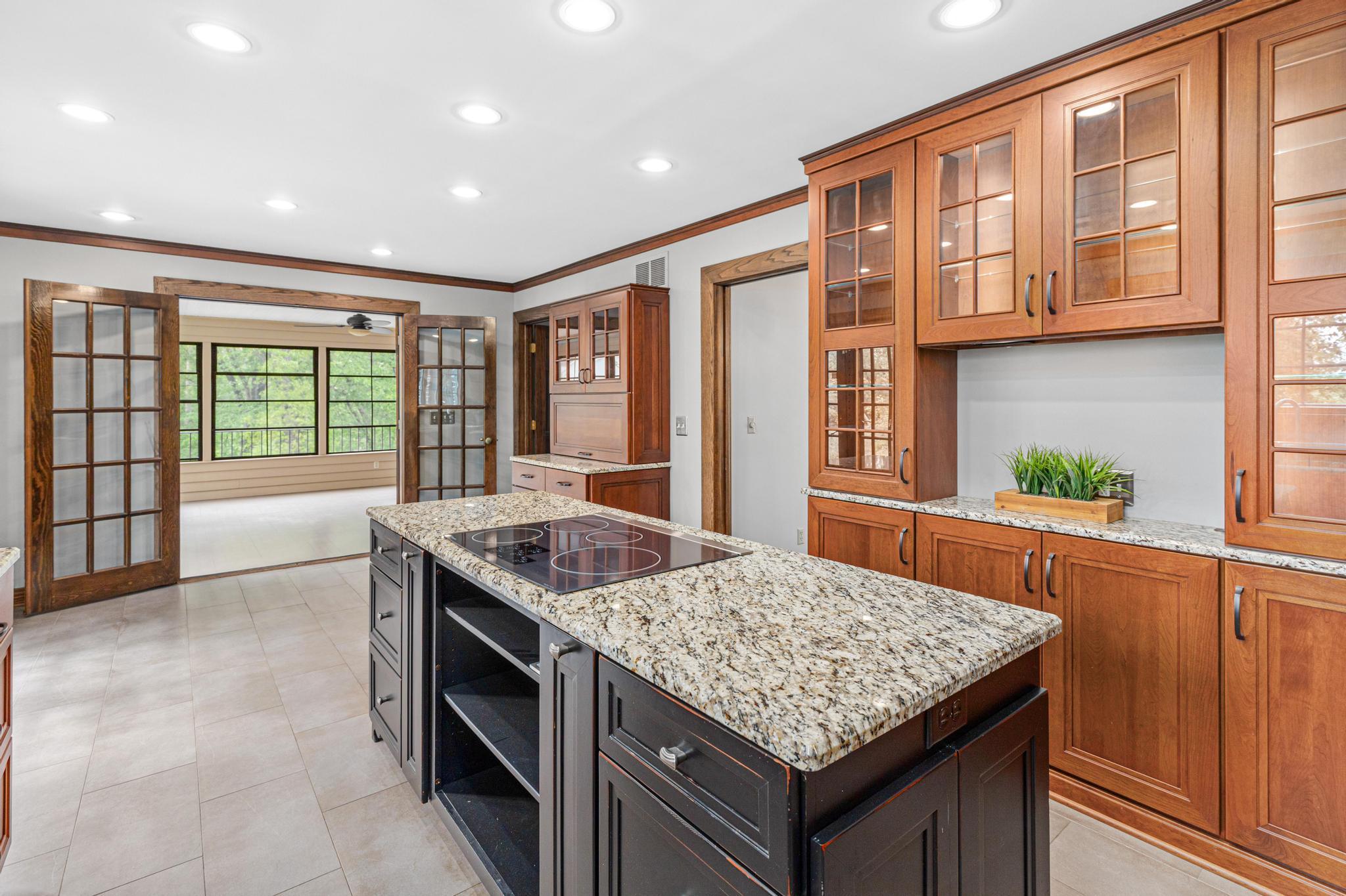 Kitchen flows seamlessly to the informal dining area and screened porch beyond. Host small and large events in this well-designed home.