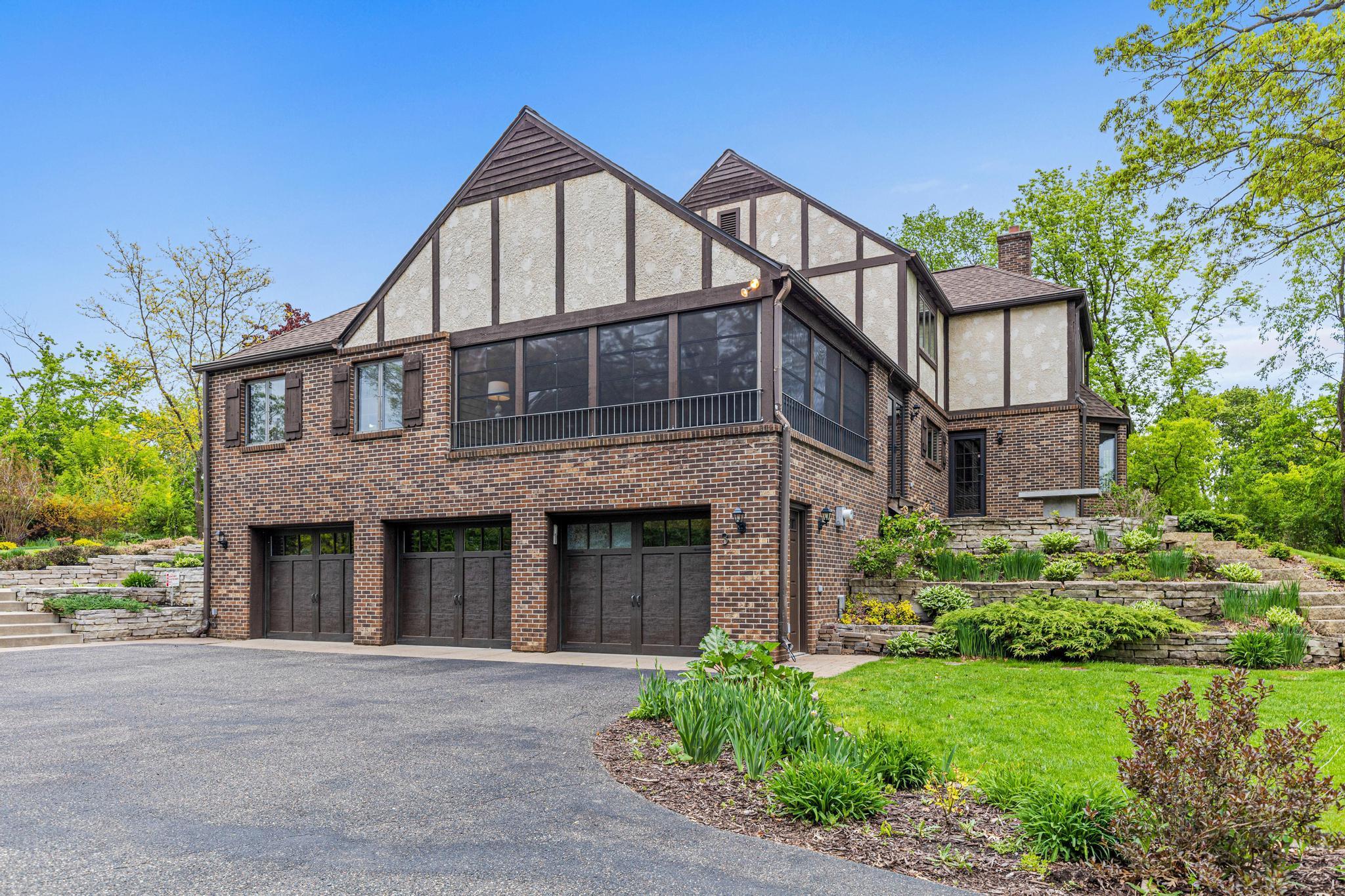 Oversized three-car garage with epoxy floor. Large driveway- perfect for guests and beautiful landscaping.