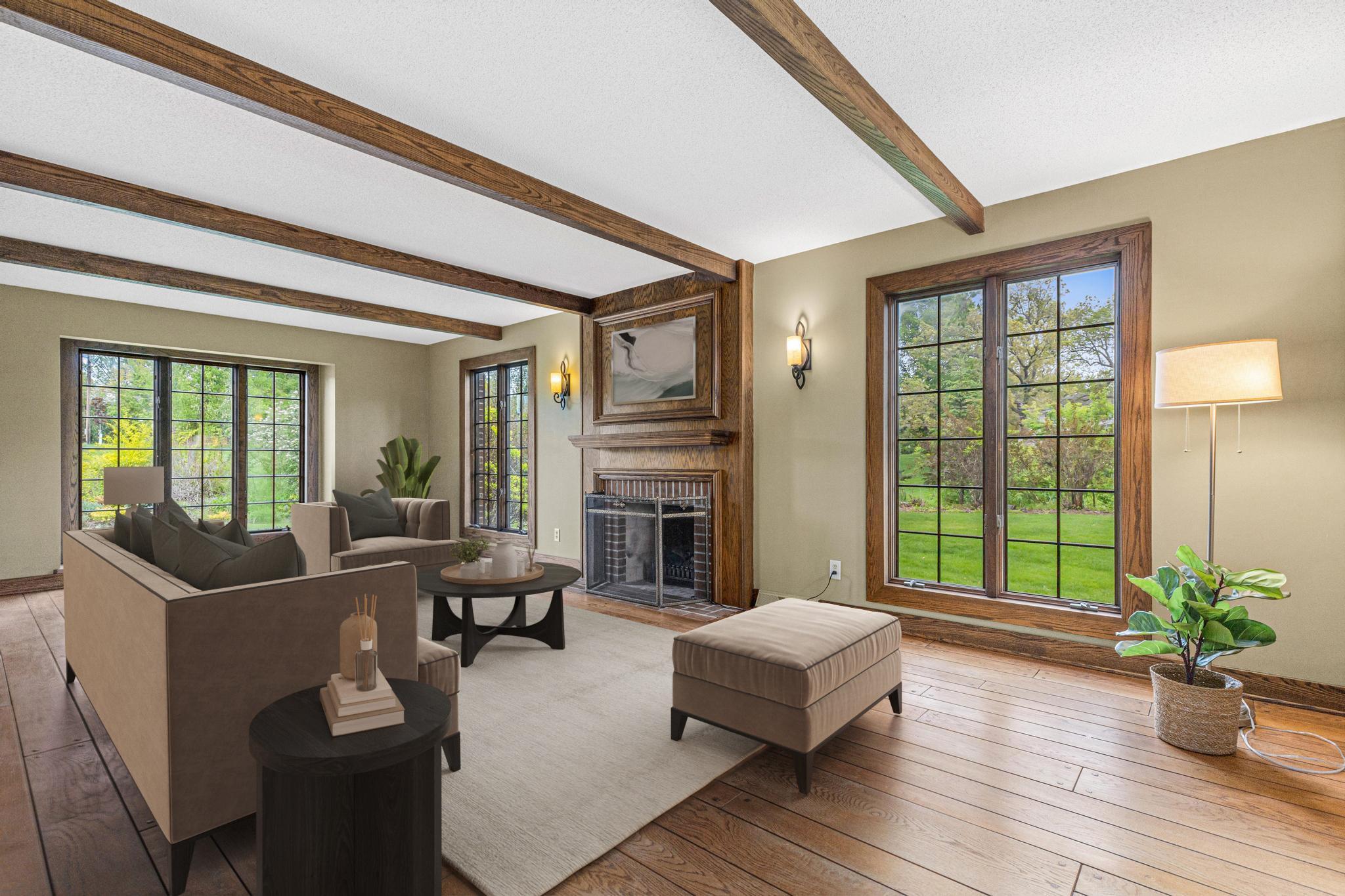 Sun-drenched living room featuring hardwood floors, electric fireplace and floor-to-ceiling windows. Visually staged to show a potential configuration.