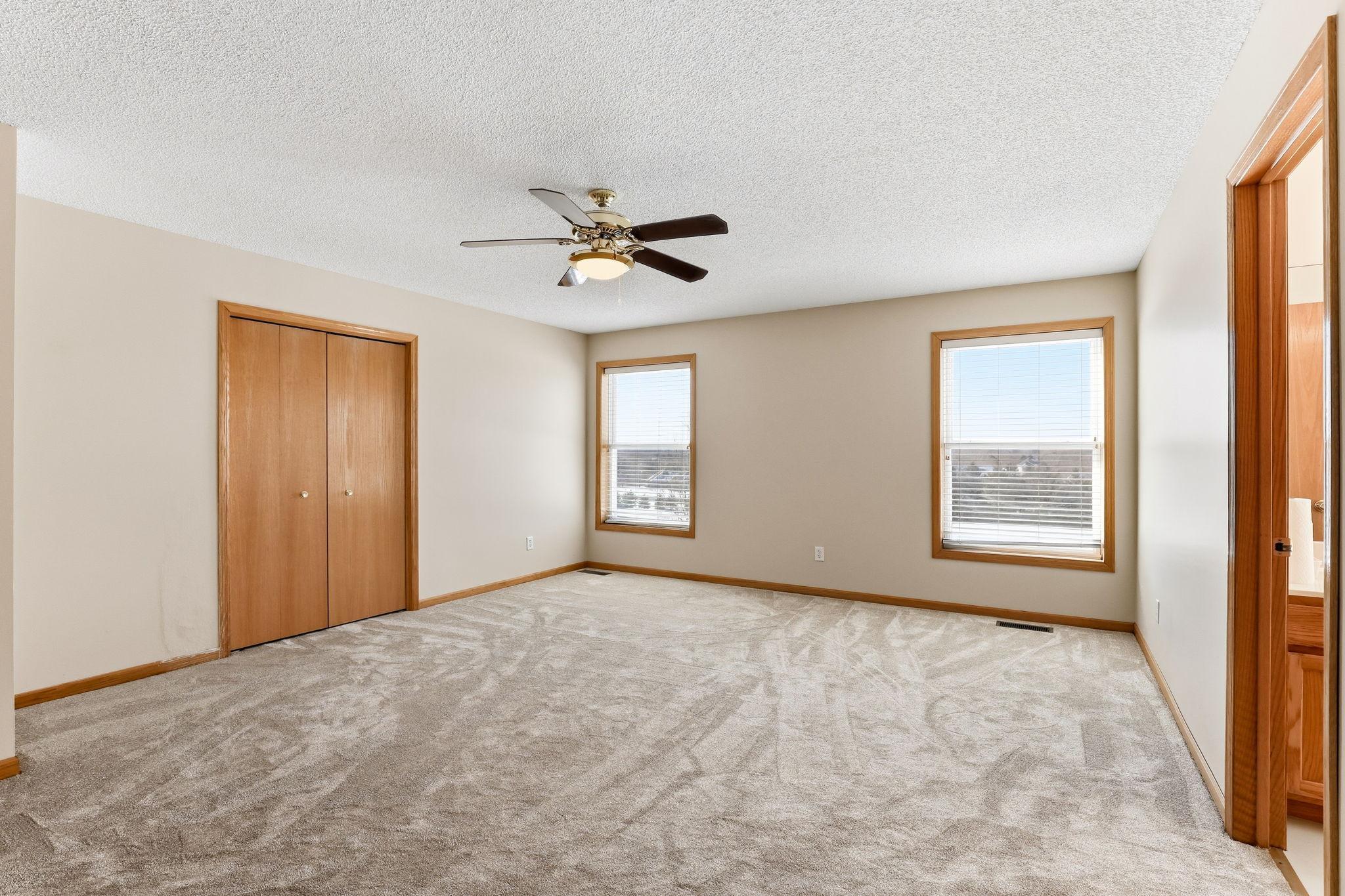 Spacious primary bedroom with dual windows; walk-in closet and additional 2nd closet