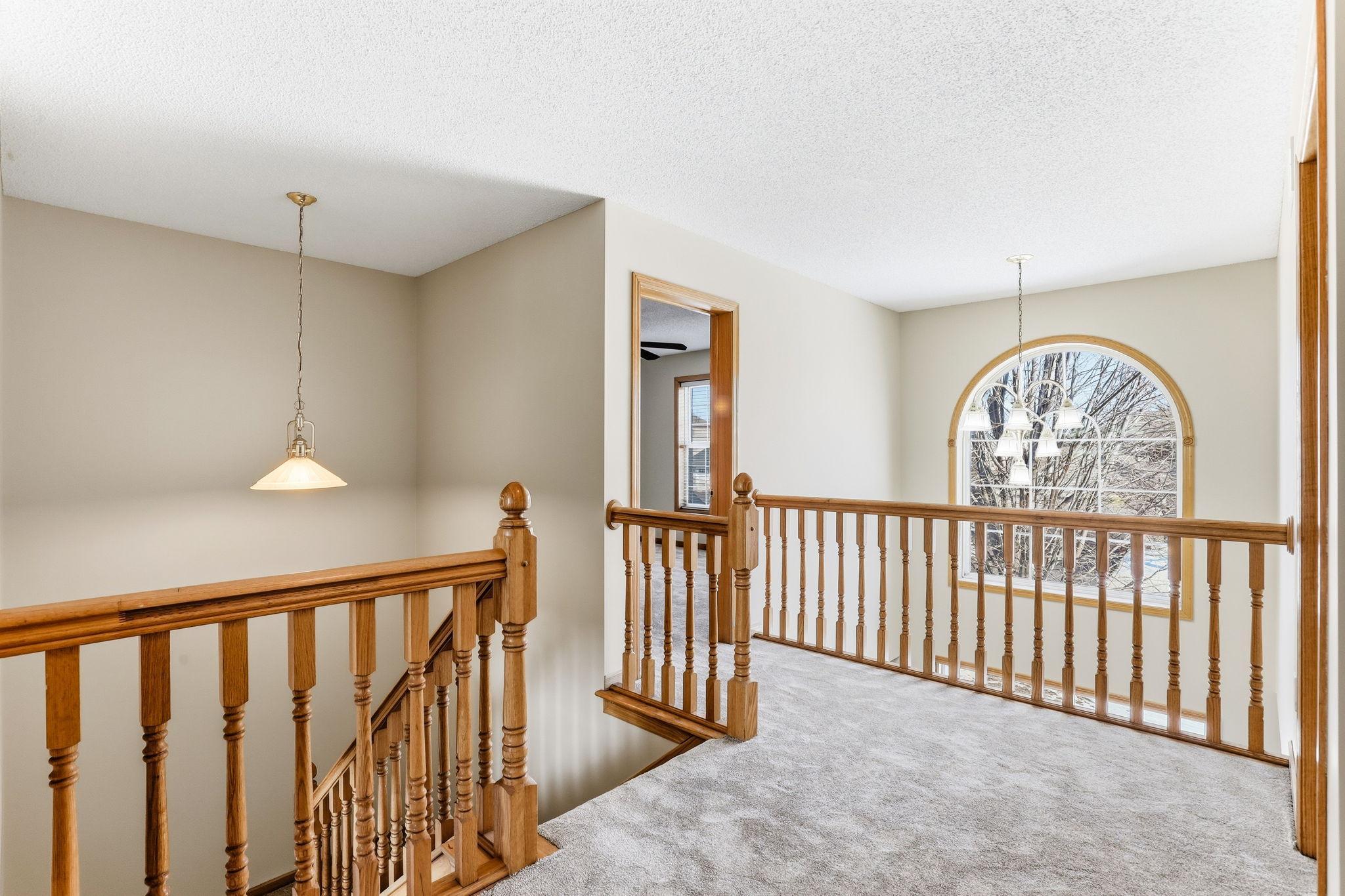 Dramatic sunlit arched window on upper level