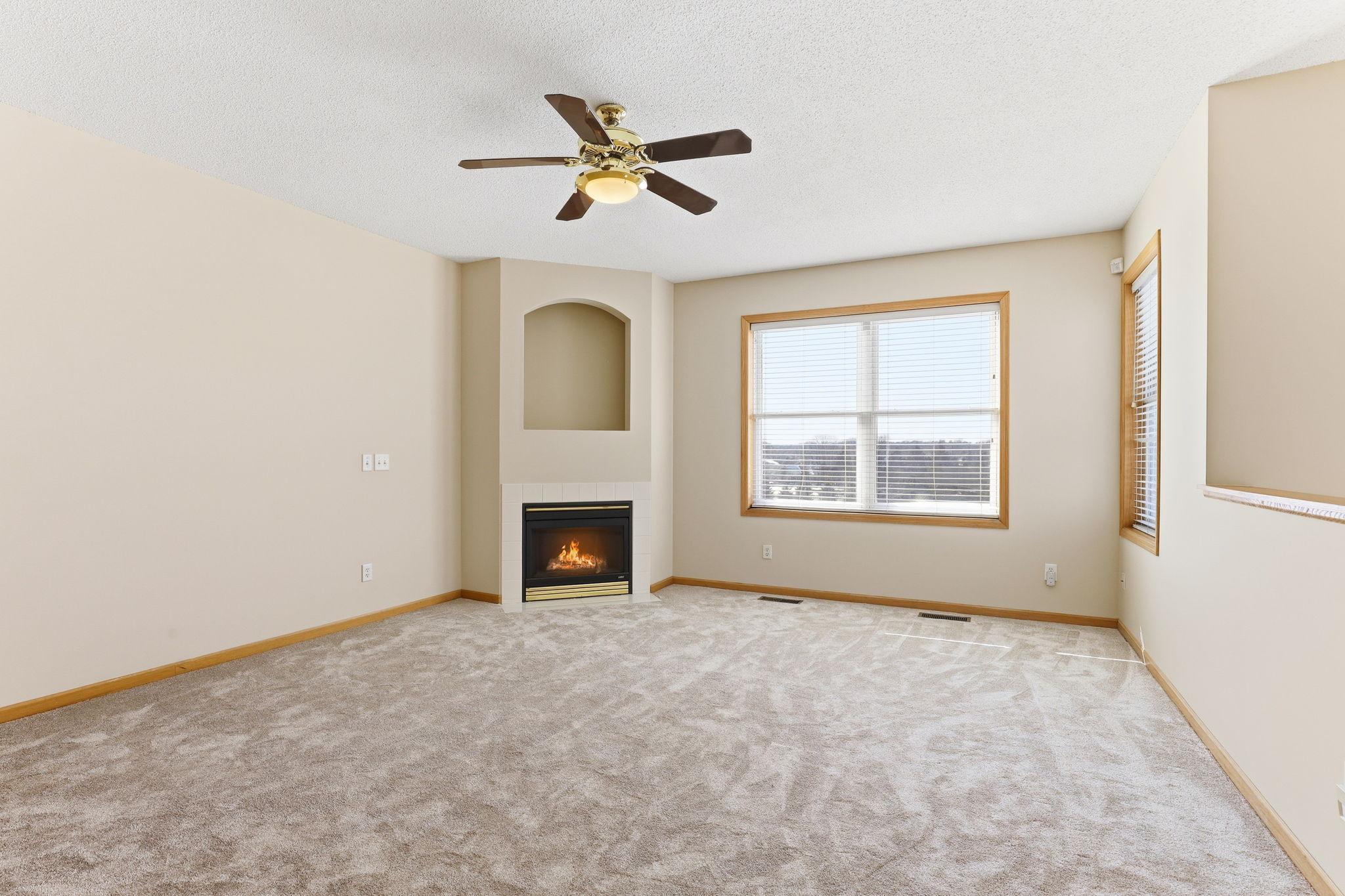 Inviting generously-sized living room with gas fireplace overlooking the golf course