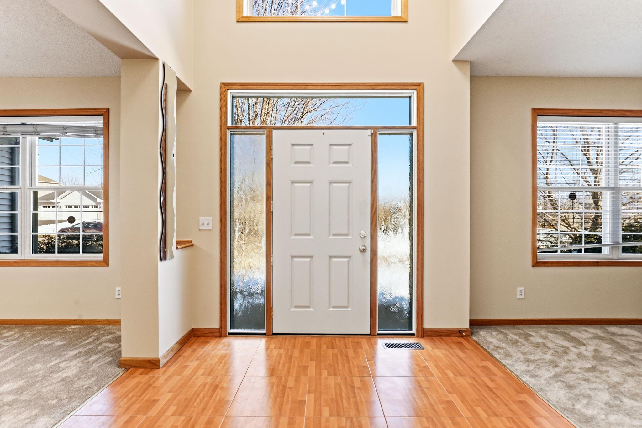 Spacious inviting foyer with new Provia door with privacy glass, and light enhancing sidelights and transom