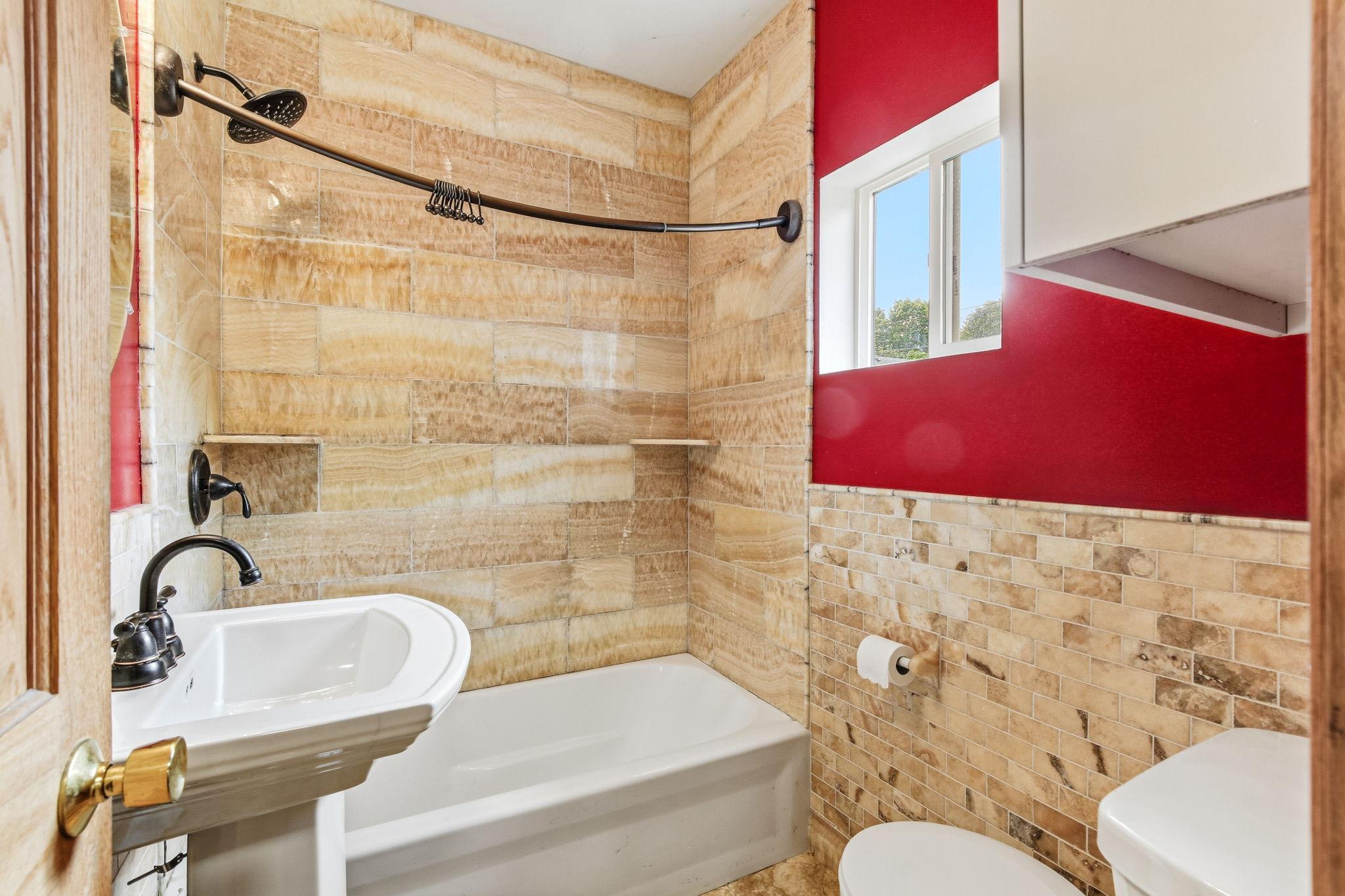 Main floor full bath with elegant tile surround!