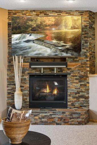 The family room's gas fireplace is framed with beautiful natural stone.