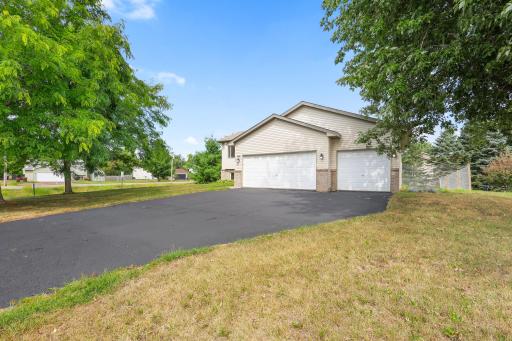 Another front view, framed by mature trees and showing more of the yard
