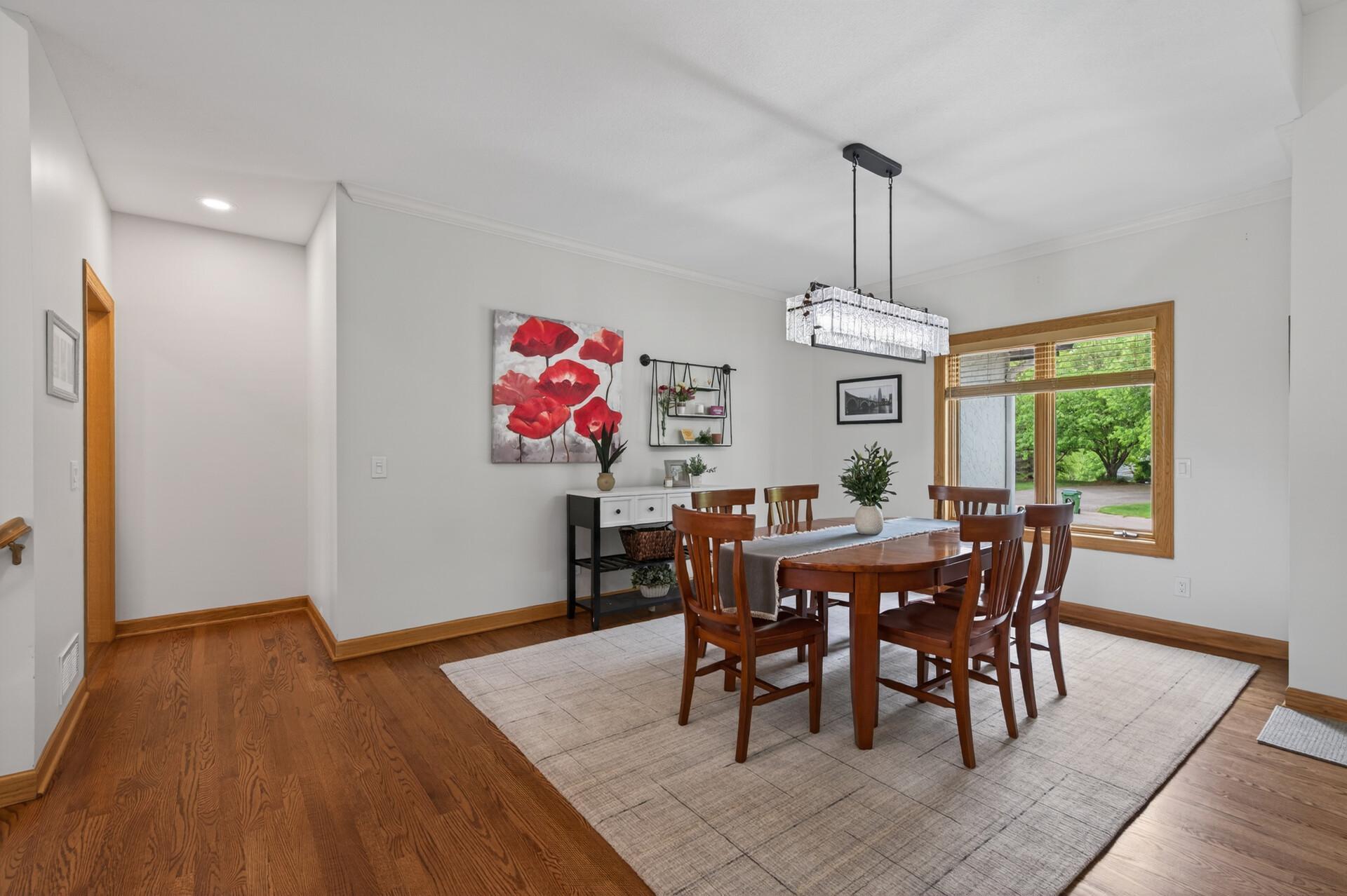 Formal dining room with hardwood floors and large picture window.