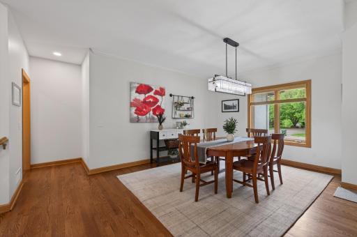 Formal dining room with hardwood floors and large picture window.