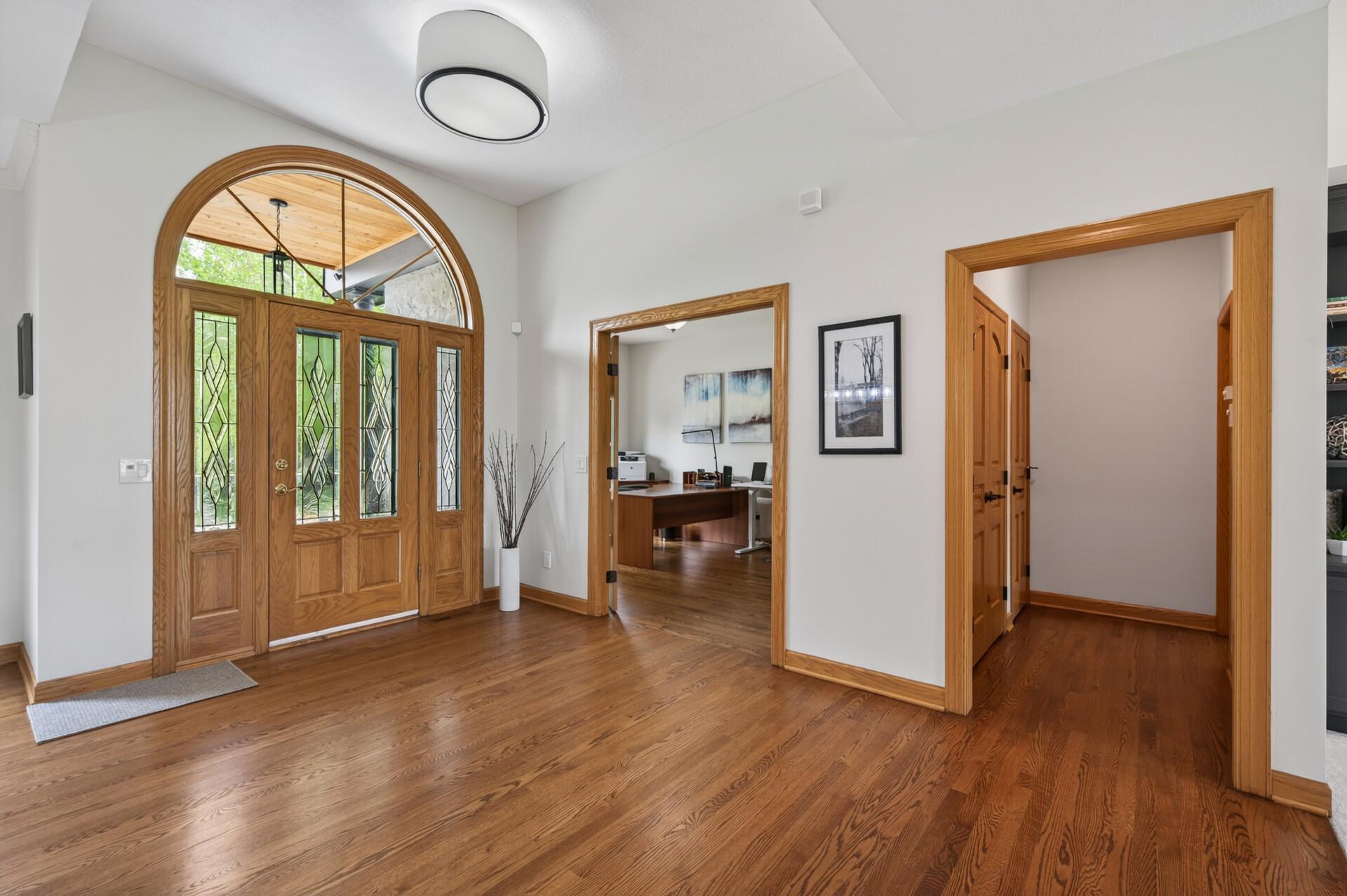 Grand foyer with arched front entry and hardwood floors.