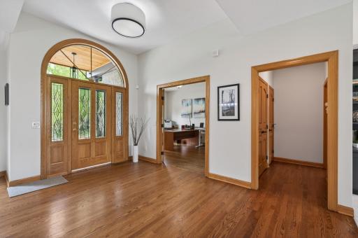 Grand foyer with arched front entry and hardwood floors.