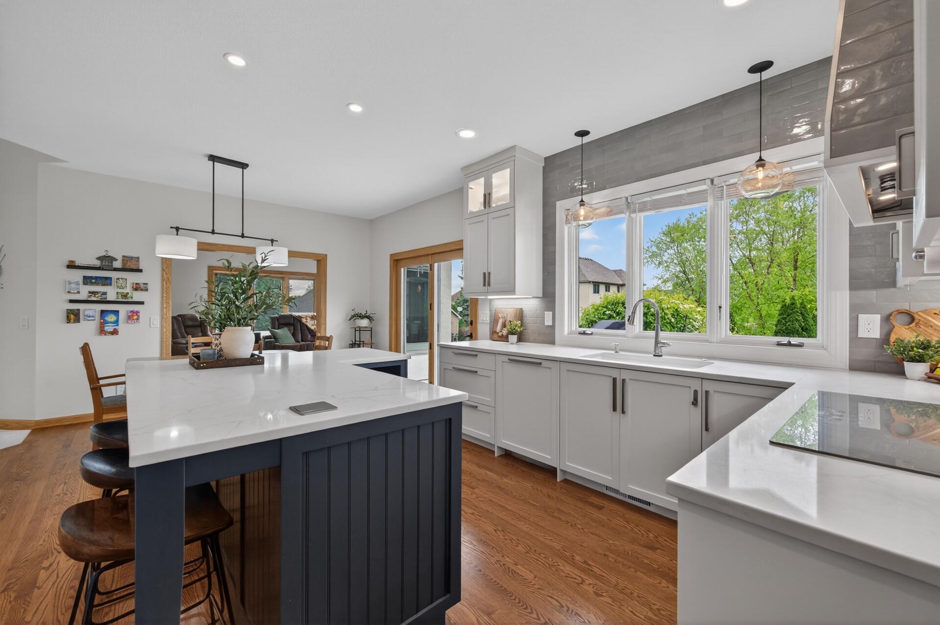 Light-filled kitchen with large windows, quartz surfaces, and modern finishes.