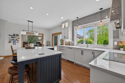 Light-filled kitchen with large windows, quartz surfaces, and modern finishes.