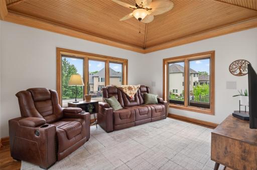 Cozy sunroom with tongue-and-groove ceiling, panoramic windows, and relaxing views.
