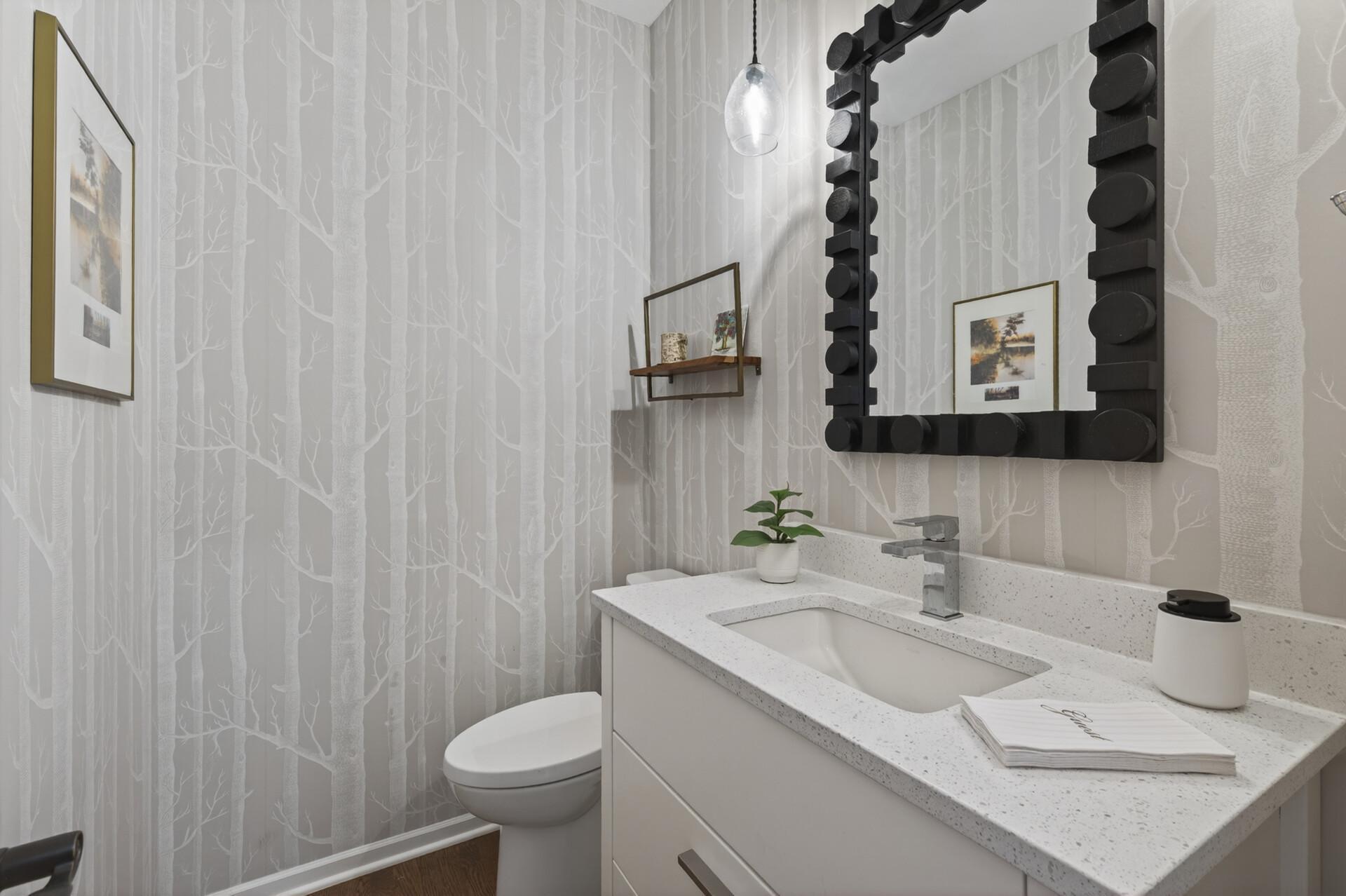 Stylish updated powder room with designer wallpaper and modern vanity.