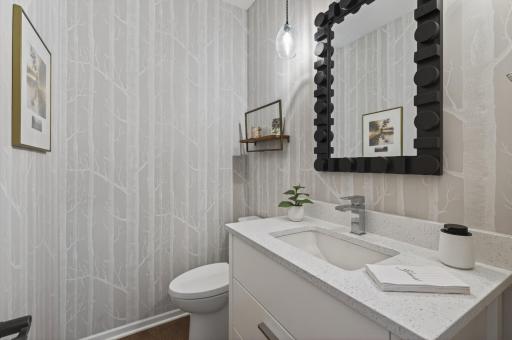 Stylish updated powder room with designer wallpaper and modern vanity.